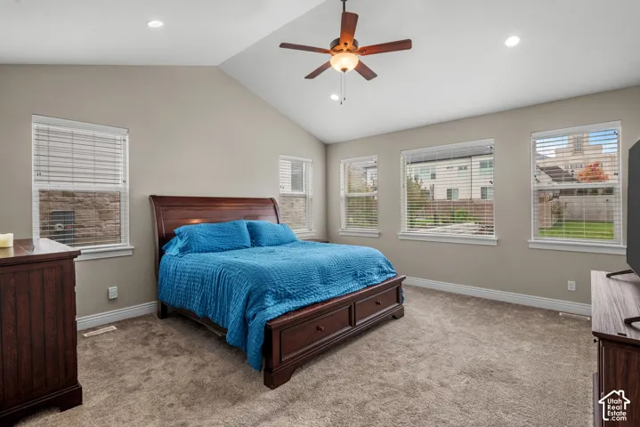 Vaulted ceilings, neutral wall tones, wall-to-wall carpeting, recessed lighting, and a centrally mounted ceiling fan with integrated light fixture
