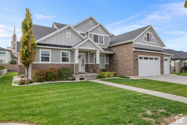 Multi-gabled exterior featuring horizontal lap siding, vertical board-and-batten siding, stone veneer, and an attached three-car garage