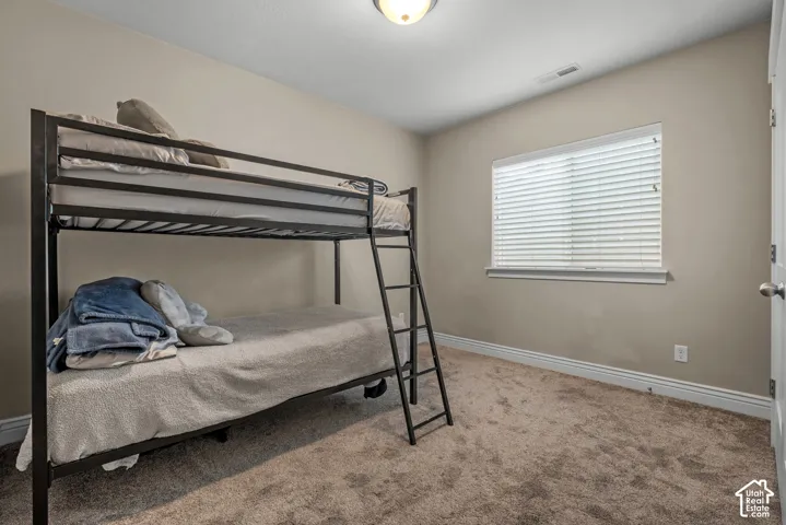 Neutral-toned interior space featuring neutral wall paint, wall-to-wall carpeting, and a window with horizontal blinds