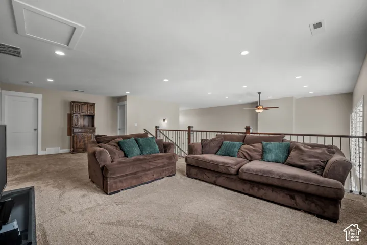 Open area featuring recessed lighting, a ceiling fan, wall-to-wall carpeting, a built-in cabinetry unit, and a metal balustrade