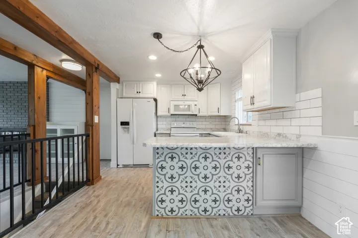 Kitchen featuring white shaker-style cabinetry, wood-finish flooring, exposed natural wood ceiling beams, a patterned tile-front island, and a subway tile backsplash.