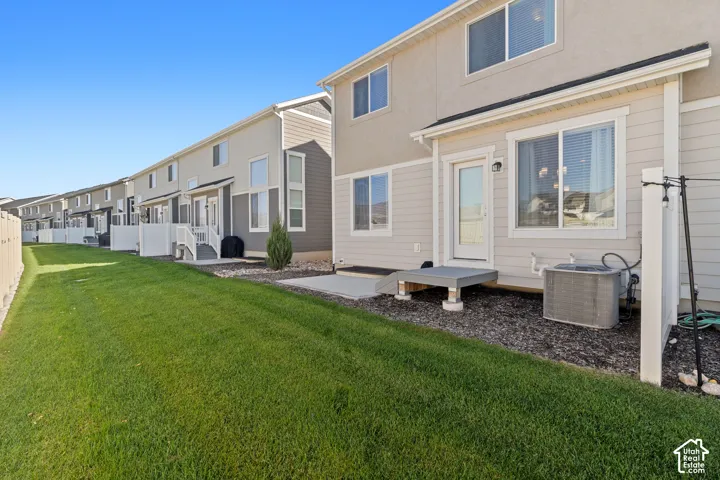 Exterior featuring a dual-tone siding facade, rear concrete patio, and a grass lawn with gravel landscaping