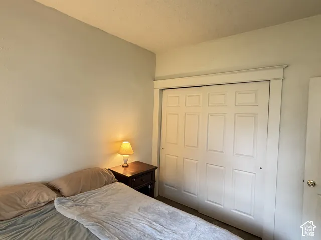 Room featuring a closet with white paneled sliding doors, framed by wide, traditional white trim molding