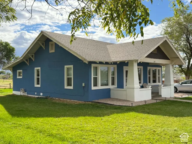 Craftsman-style exterior featuring a covered front porch, tapered support columns, decorative roof brackets, and a manicured lawn