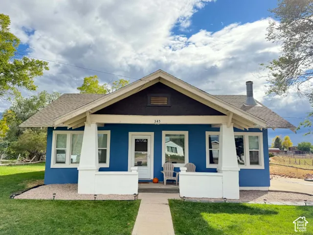 Craftsman-style exterior featuring a covered front porch with tapered columns, gable roofline, multi-pane windows, and exterior chimney