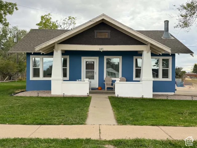 Craftsman-style exterior featuring a covered front porch, tapered support columns, textured gable detailing, and a chimney