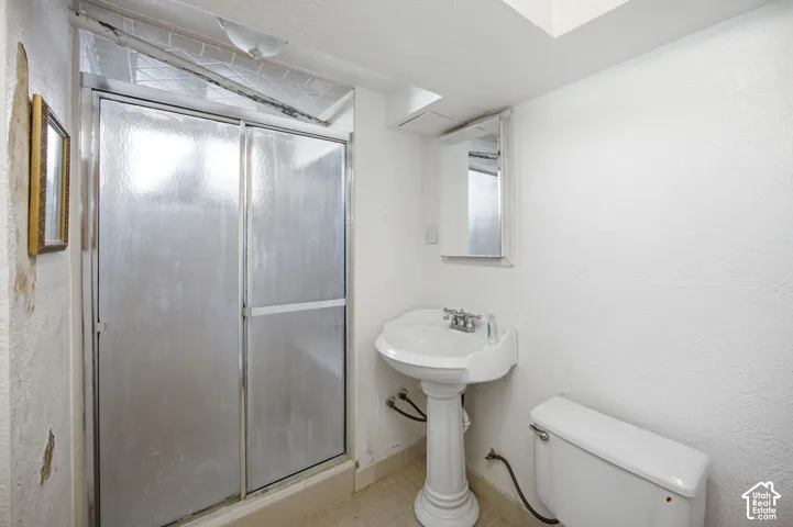 Bathroom featuring a glass-enclosed shower, pedestal sink, mirrored medicine cabinet, and standard toilet