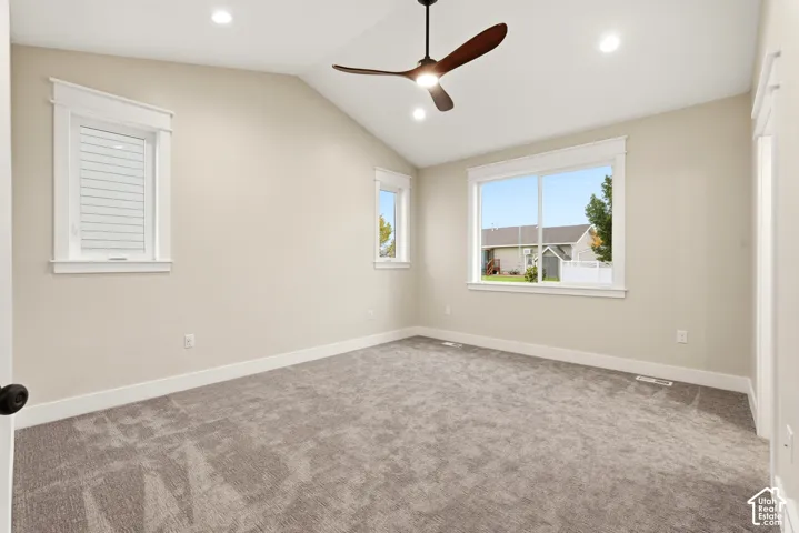 Vaulted ceiling, neutral wall tones, wall-to-wall carpeting, recessed lighting, and a modern three-blade ceiling fan