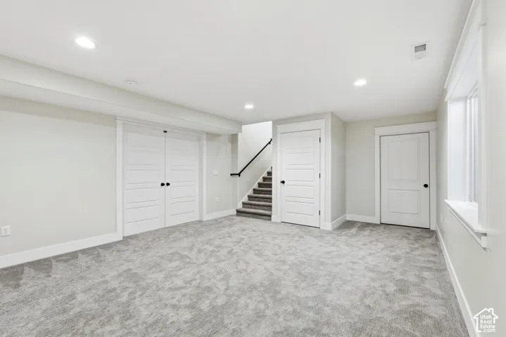 Interior room featuring wall-to-wall carpeting, recessed ceiling lighting, double-panel interior doors, and a window with a sill