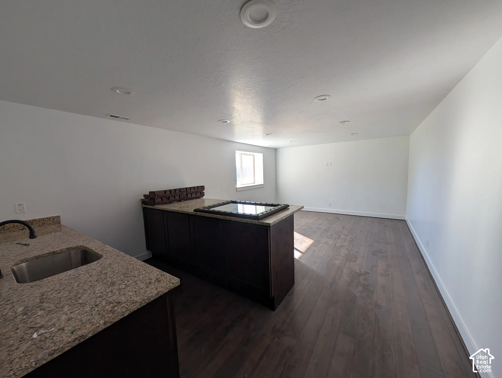 This kitchen doesn't have a stove, but it does have a sink, under-counter fridge, cabinet space and a HUGE island.