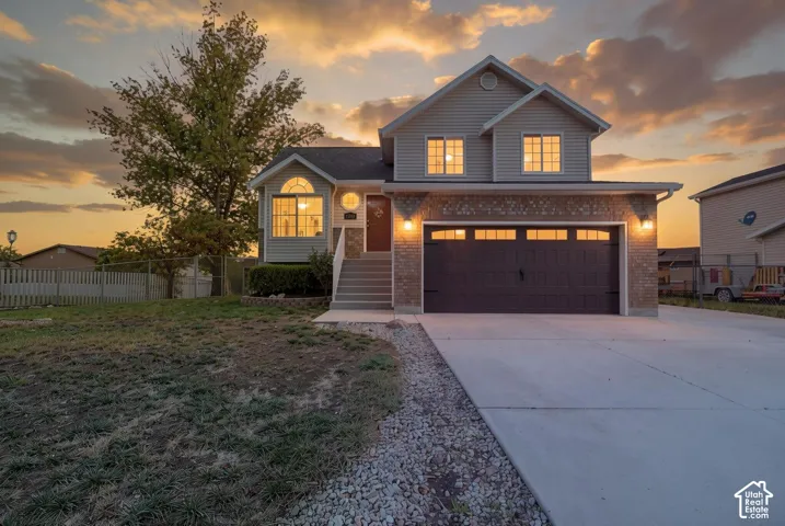 Two-story residence featuring a brick and horizontal siding exterior, attached two-car garage, concrete driveway, and arched window detailing
