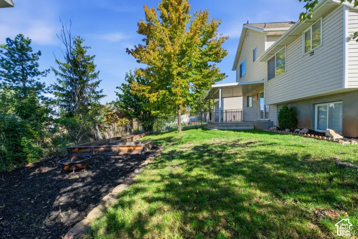 Backyard featuring a covered patio, raised garden beds, and mature trees