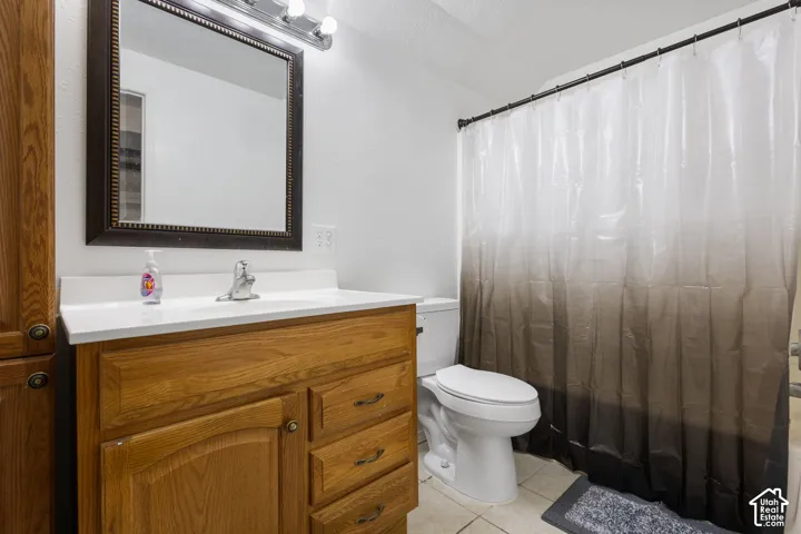 Bathroom featuring a wood-finish vanity with a white countertop, framed wall mirror, and integrated vanity lighting