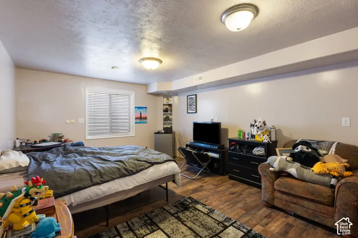 Wood-finish flooring, recessed built-in shelving, two flush-mount light fixtures, and a window with horizontal blinds