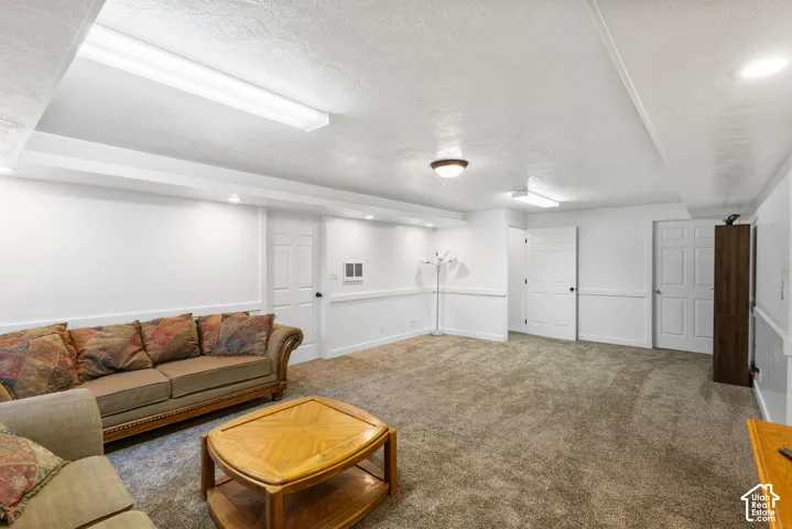 Neutral-toned carpeting, recessed ceiling lighting, textured wall finish, chair rail molding, and multi-panel interior doors