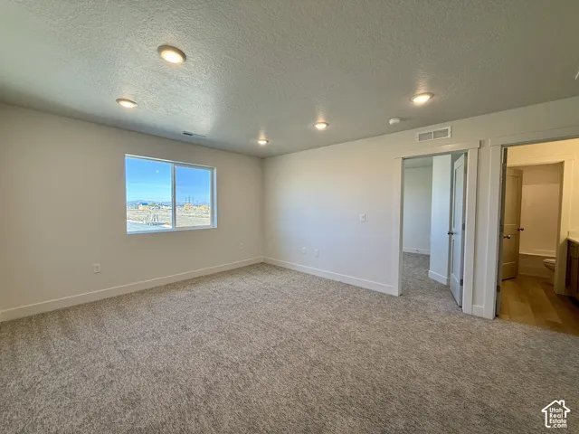 Neutral-toned carpeting, recessed ceiling lighting, and a single-hung window