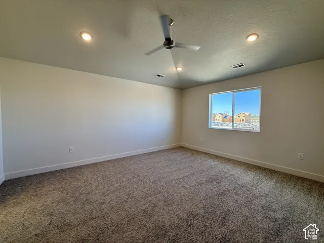 Neutral-toned wall-to-wall carpeting, recessed ceiling lighting, and a modern ceiling fan