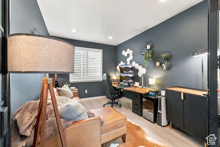 Room featuring wood-finish flooring, recessed lighting, and plantation shutters