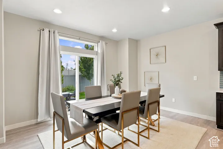 Neutral-toned interior featuring recessed lighting, wood-finish flooring, and a large sliding glass door with a transom window