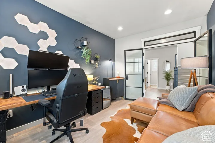 Interior room featuring metal-framed glass doors, wood-finish flooring, recessed lighting, and a neutral color palette