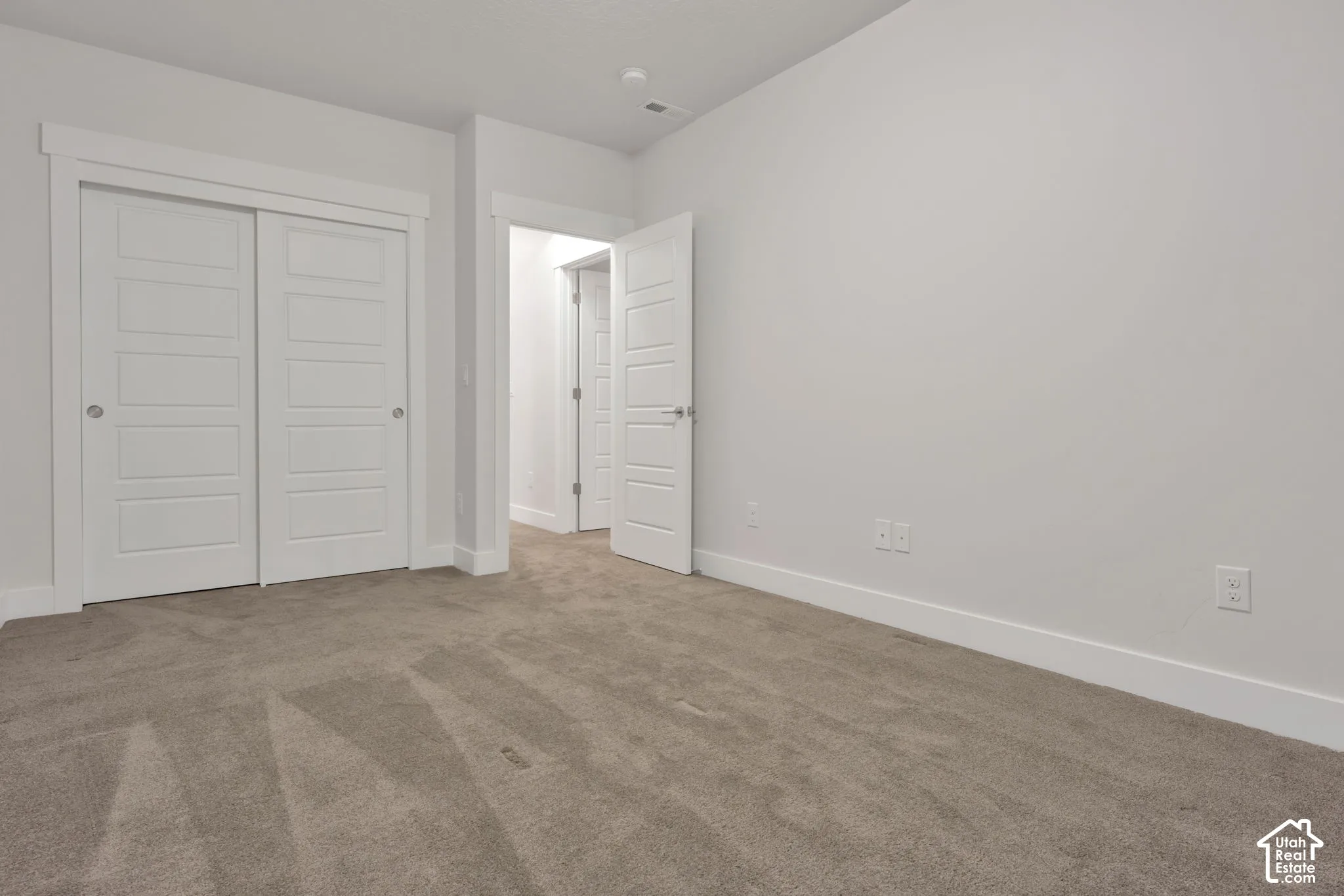Neutral-toned carpeting, white shaker-style interior doors, and clean-lined millwork trim throughout