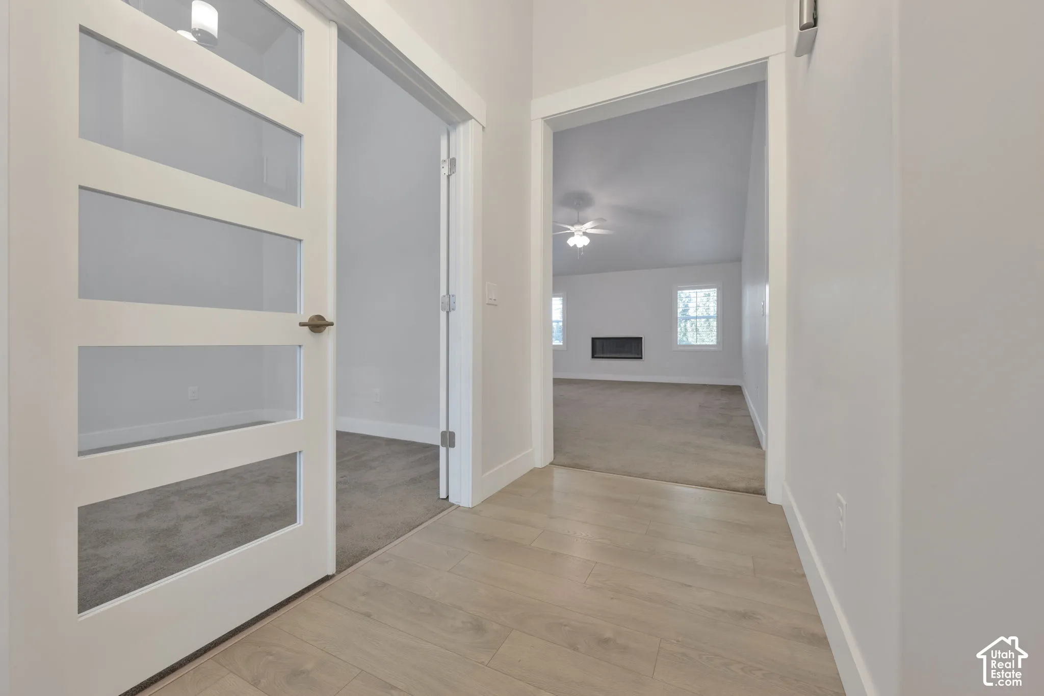 White-painted four-panel glass-inset door, light-toned wood-finish flooring, french doors to flex room.