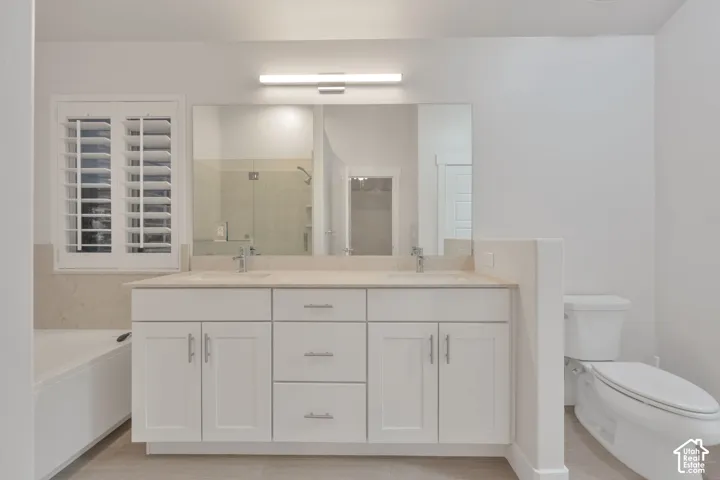 Dual-sink vanity with light-toned countertop, white cabinetry with silver-finish hardware, full-width mirror, wall-mounted light fixture, and plantation shutters