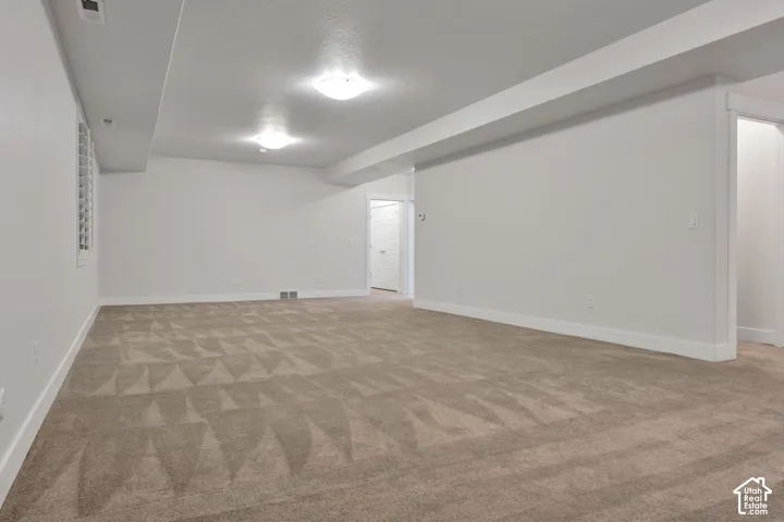 Neutral interior room with wall-to-wall carpeting, recessed ceiling lighting, and crisp white walls