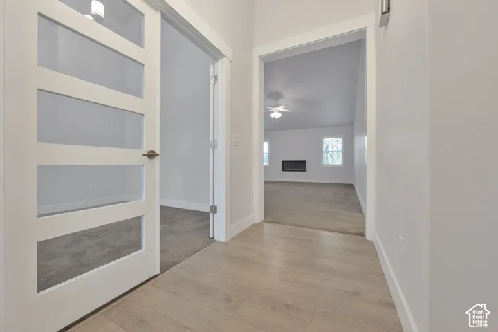 White-painted four-panel glass-inset door, light-toned wood-finish flooring, french doors to flex room.