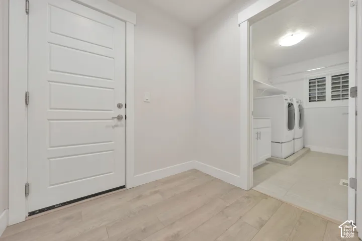 Four-panel door with satin nickel hardware, wood-finish flooring, and white door casings