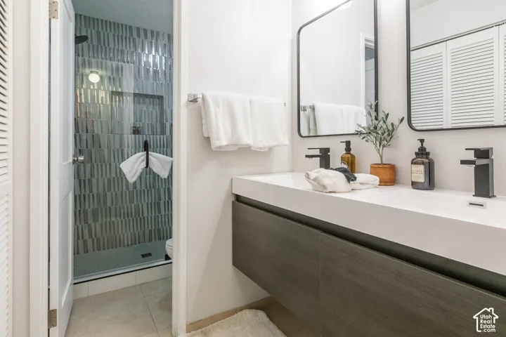 Dual vanity with integrated sinks, black finish faucets, framed mirrors, and wood-finish cabinetry