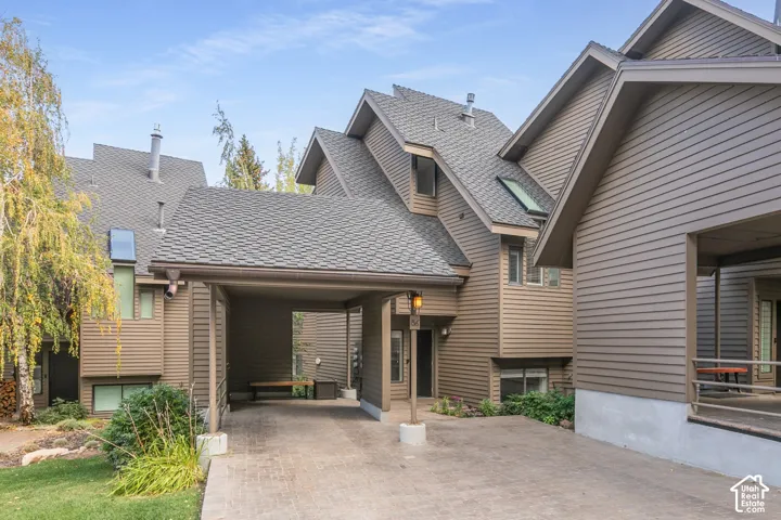 Exterior featuring multi-level rooflines, skylight, car port, horizontal siding, and a covered porch