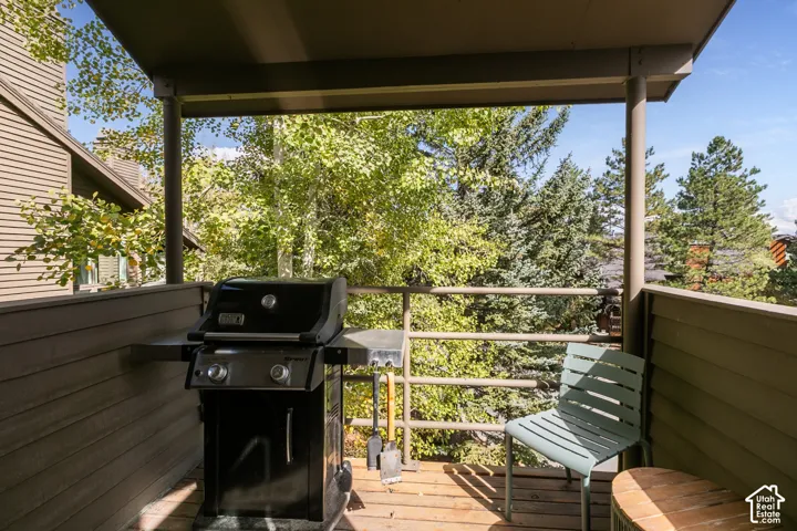 Covered outdoor deck with wood flooring and metal railings