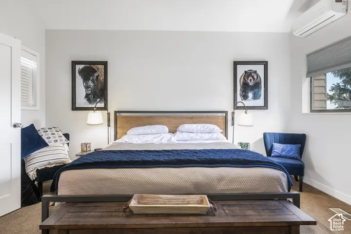 Light-colored walls, window with blinds, wood-finish headboard, built-in light fixtures, wall-mounted climate control unit