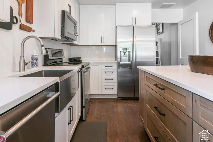 Modern kitchen featuring stainless steel appliances, including a gas cooktop and under-mount sink with pull-down faucet