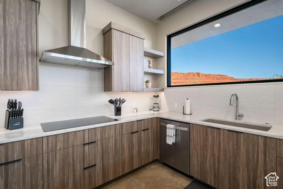 Kitchen featuring wood-finish cabinetry, stone countertops, stainless steel range hood, integrated dishwasher, and landscape backdrop