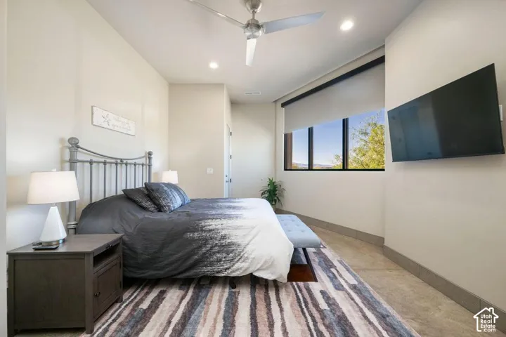 Room featuring neutral wall paint, large picture window with blackout roller shade, recessed lighting, and a brushed nickel ceiling fan