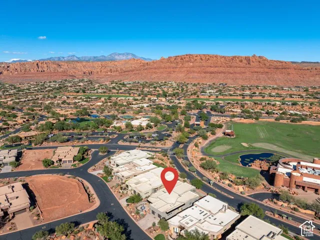 Aerial perspective featuring desert landscape, proximity to golf course greens, and red rock mountain backdrop