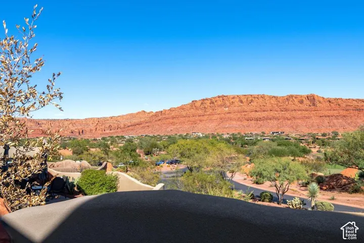 Expansive terrace featuring a stone wall, integrated landscaping, and prominent red rock mountain scenery