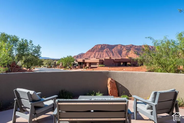 Exterior patio featuring a concrete surface, a stucco privacy wall, and desert mountain scenery
