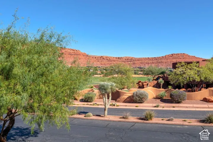 Red rock mesa backdrop, native desert landscaping, and xeriscaped ground cover
