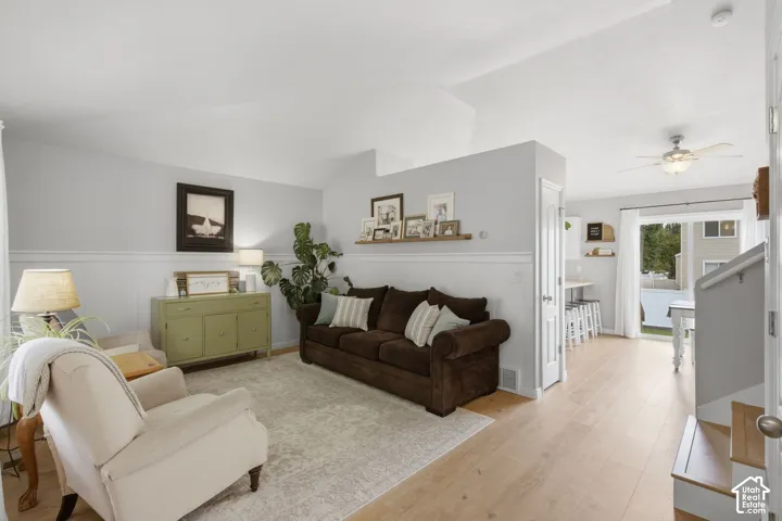 Vaulted ceilings, wood-finish flooring, wainscoting, and a ceiling fan