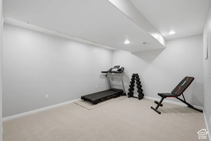 Neutral-toned interior space featuring light-colored wall-to-wall carpeting and recessed ceiling lighting