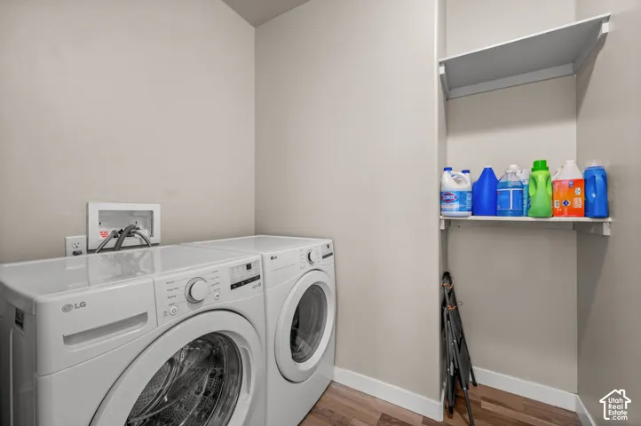 Dedicated laundry alcove featuring wood-finish flooring and integrated wall-mounted shelving