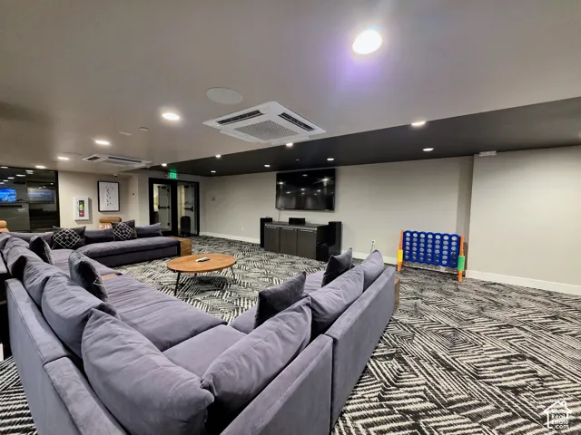 Expansive interior space featuring recessed ceiling lighting, integrated cassette HVAC units, and patterned wall-to-wall carpeting