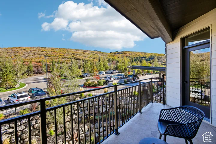 Covered balcony featuring black metal railings and a stacked stone retaining wall