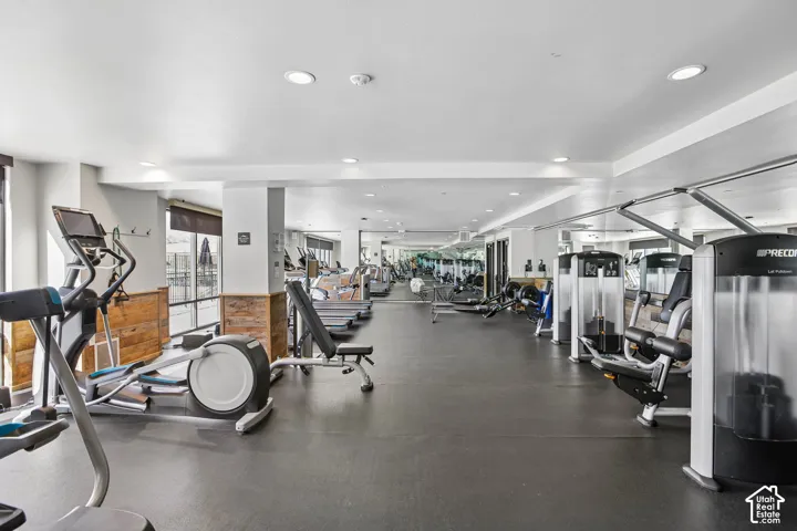 Fitness facility featuring rubberized flooring, recessed lighting, and wood-paneled walls