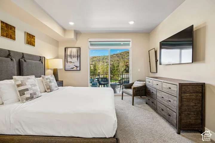 Neutral wall tones, recessed lighting, sliding glass door, and exterior balcony featuring mountain scenery