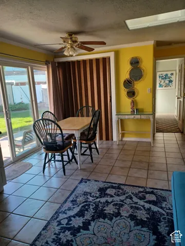 Ceramic tile flooring, sliding glass door, ceiling fan with integrated lighting, and a skylight
