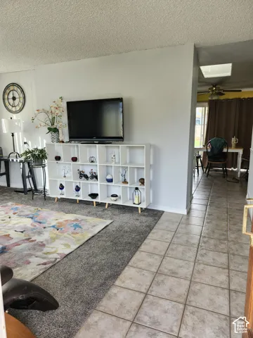 Neutral-toned interior featuring square ceramic tile flooring, neutral wall paint, and a skylight